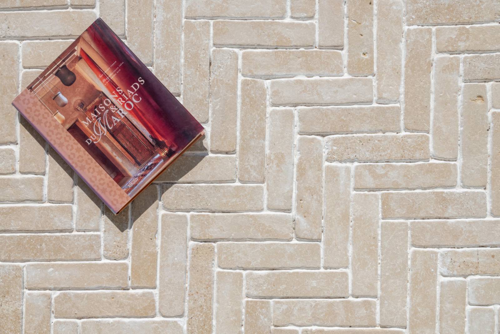 Outdoor terrace in Chablis beige natural stone from Morocco – 20x5 cm cobbles with Ussé finish – elegant Burgundy limestone look.