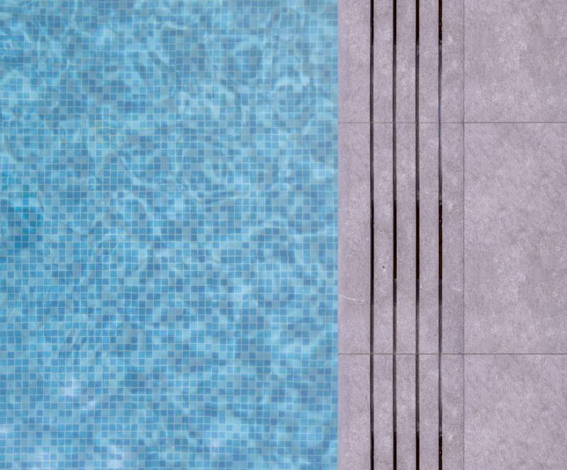 Margelle de piscine en pierre naturelle grise à bon prix, réalisée sur mesure : paysagisme et architecture tendance à Nice, en Côte d'Azur