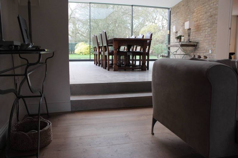 Interior floor in natural stone from Morocco in rustic finish with parquet and wooden furniture