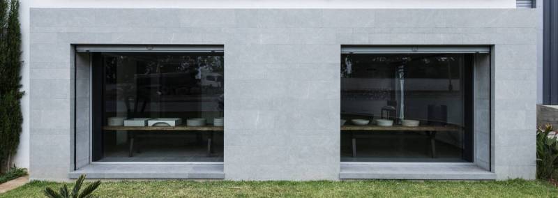 Minimalist and authentic architecture: brushed flamed gray Kahla natural stone for facades with a raw and textured appearance
