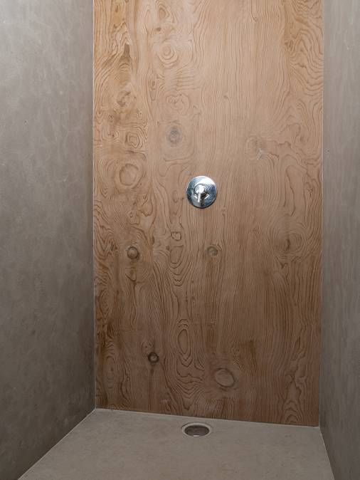 Walls in giant formats cut in Avalon gray natural stone and Italian shower tray machined in the mass in brushed natural stone