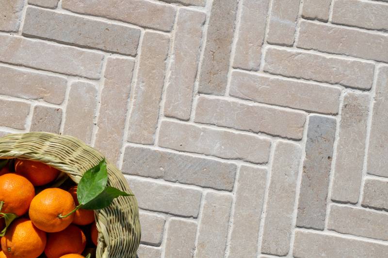 Herringbone paving with beige natural stone cobbles from Morocco – Amazon Beige blend – a refined Burgundy limestone look for outdoor design.