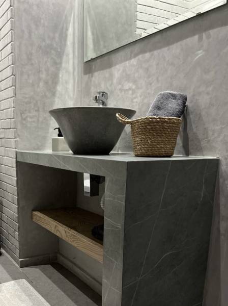 Elegant bathroom coating in stone with carved out stone sink in architect's house in Los Angeles, California. Low price for great quality